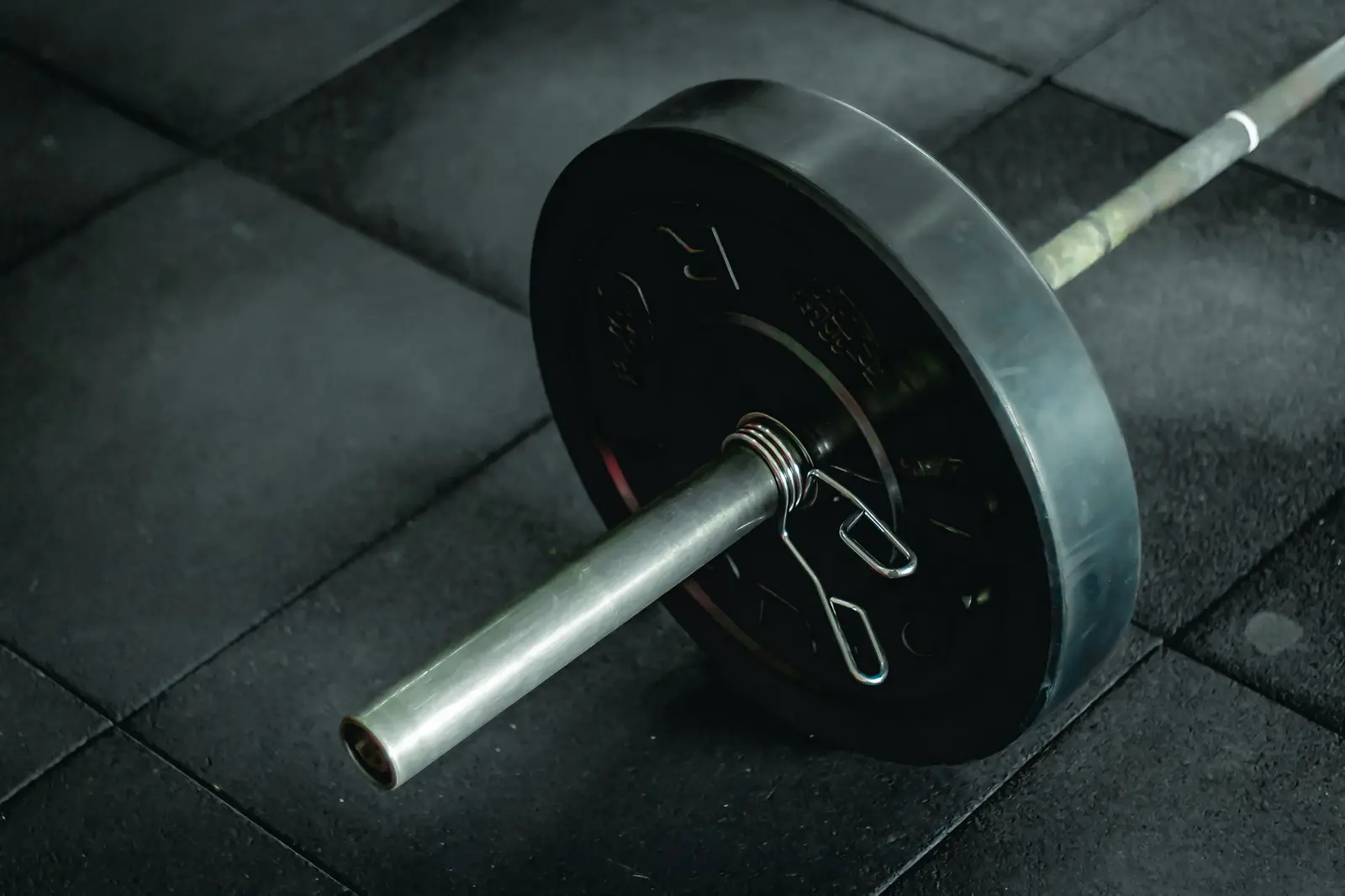 Disco y barra en el suelo de un gimnasio